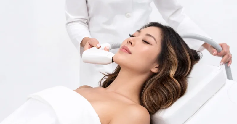 Clinician applying a Sofwave handpiece beneath a client’s chin.