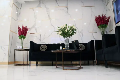 Waiting lounge with velvet sofas and fresh flowers at Privato Clinic Asoke